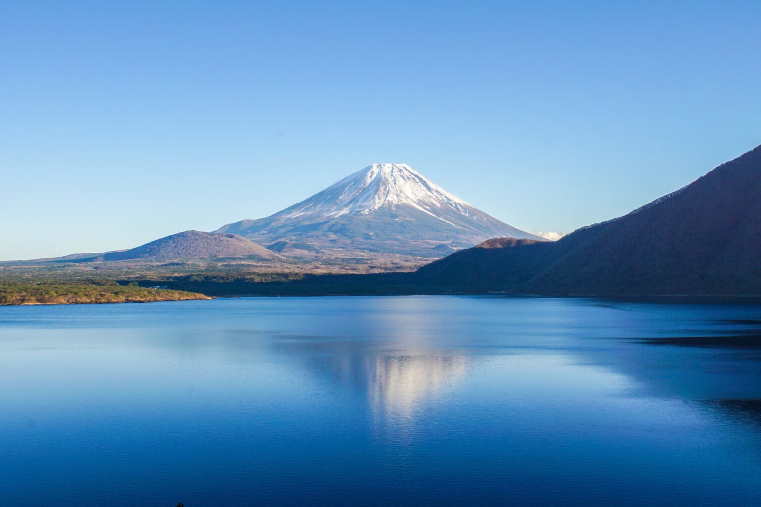 富士山と大きな湖の絶景風景、日本の自然と山岳風景を象徴的に表現しています。.